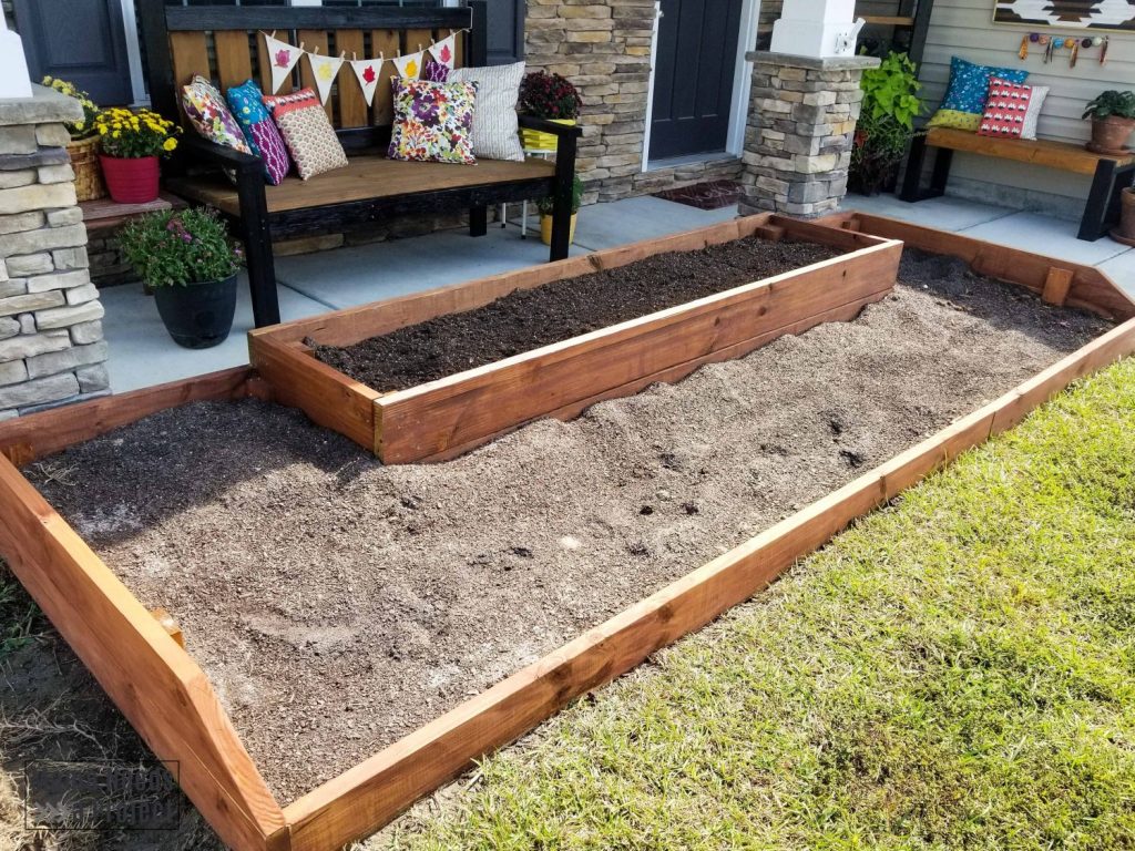 wood raised flower bed in front of home
