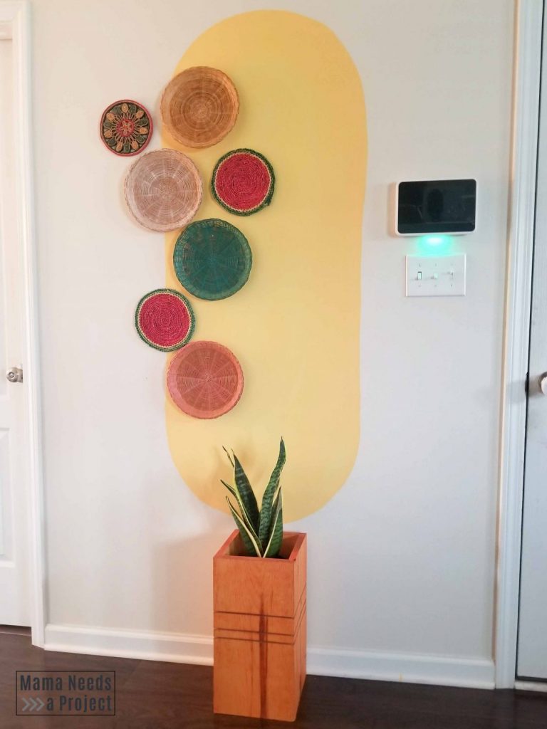 diy modern wood planter in front of wall with big yellow oval and colorful baskets