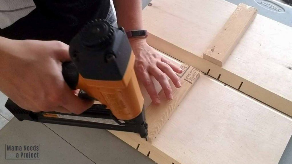 using a brad nailer to secure 1x2 supports for the plant shelf