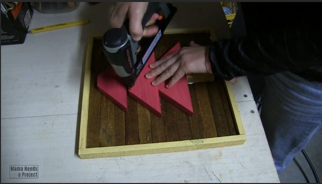 use brad nailer and wood glue to attach scrap wood christmas tree to backing