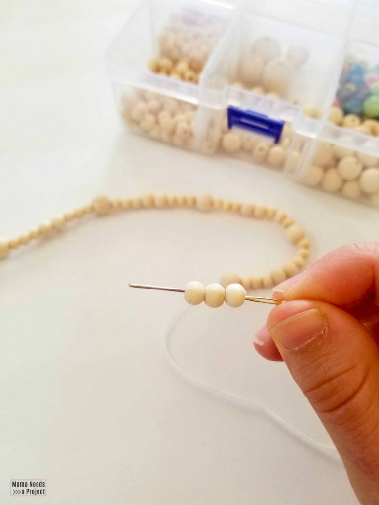 thread beads onto string using an embroidery needle