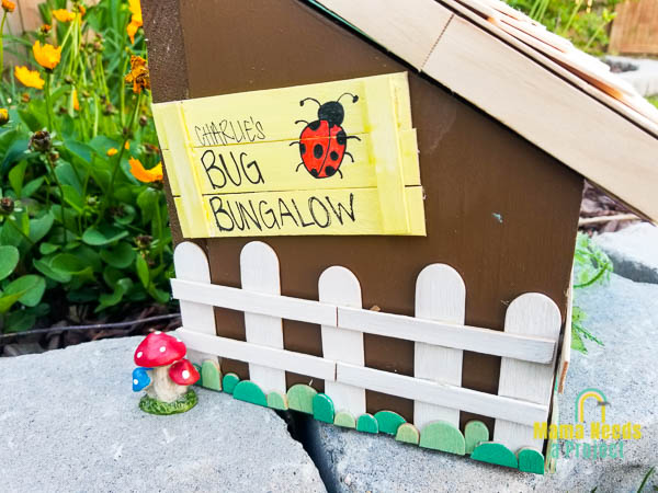 charlie's bug bungalow sign on side of diy bug house decorated with popsicle sticks