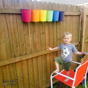 mounting upcycled plastic nursery pots to fence with a toddler